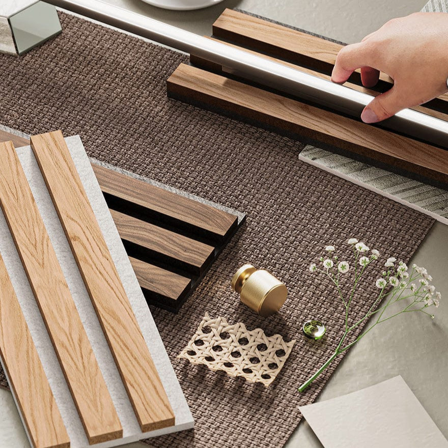 Wooden wall panel samples and a small decorative item on a textured surface with a hand holding a coaster.